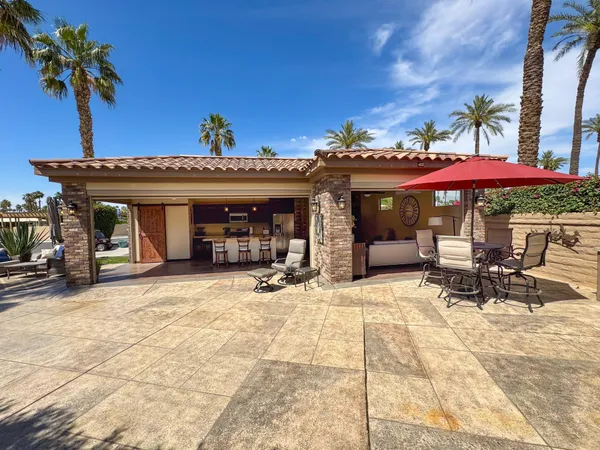 a view of a house with potted plants and palm trees