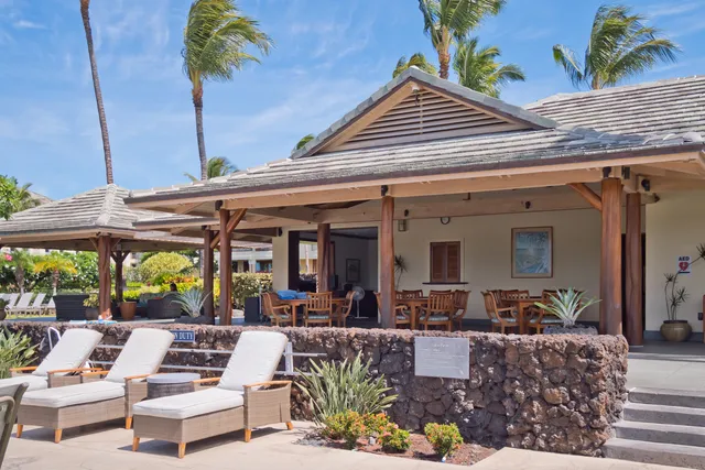 a view of a patio with couches table and chairs under an umbrella