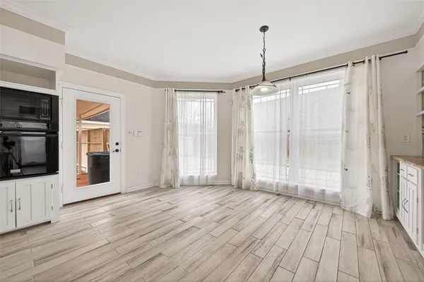 a view of a kitchen with wooden floor fridge and front door