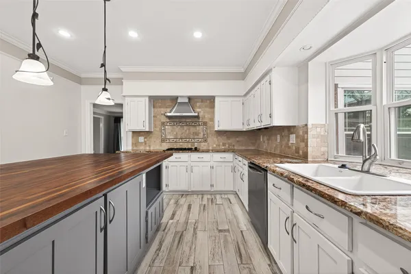 a kitchen with stainless steel appliances granite countertop a sink a stove and a wooden floors