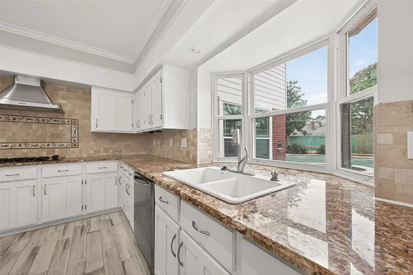 a kitchen with granite countertop sink and window