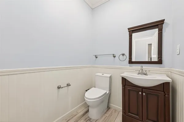 a bathroom with a toilet a sink and mirror