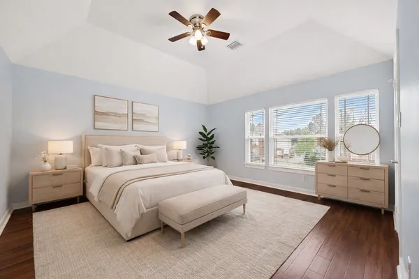 a spacious bedroom with a large bed and a chandelier