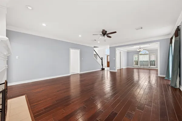 a view of a livingroom with wooden floor and a ceiling fan