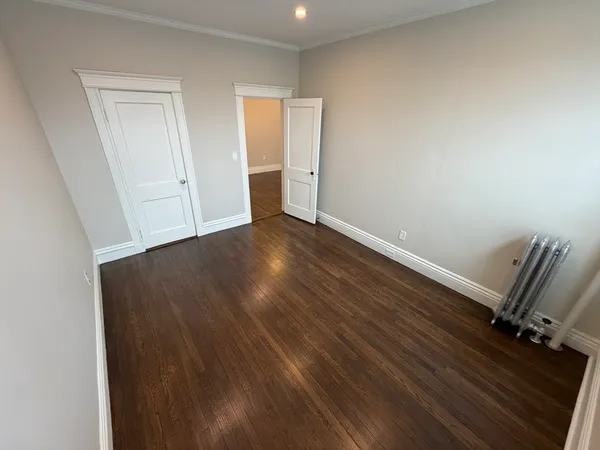an empty room with wooden floor and closet