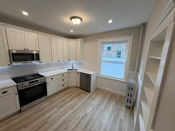 a large kitchen with a stove sink and cabinets