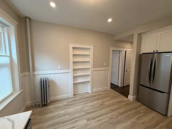 a view of a refrigerator in kitchen and wooden floor