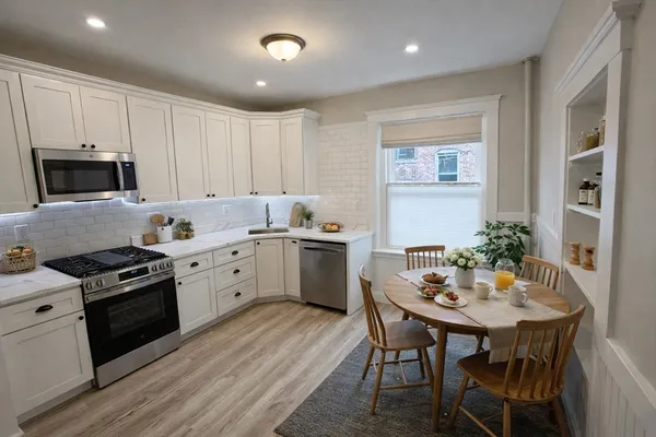 a kitchen with a sink stove cabinets dining table and chairs
