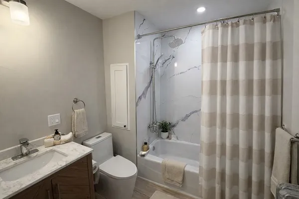 a bathroom with a granite countertop sink toilet and shower