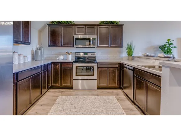 a kitchen with stainless steel appliances granite countertop a stove a sink and a microwave