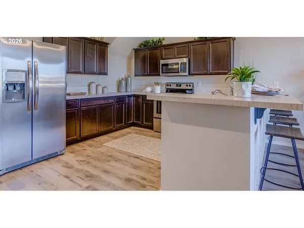 a kitchen with kitchen island a counter top space cabinets and stainless steel appliances