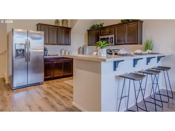 a kitchen with stainless steel appliances kitchen island granite countertop a refrigerator and a stove top oven