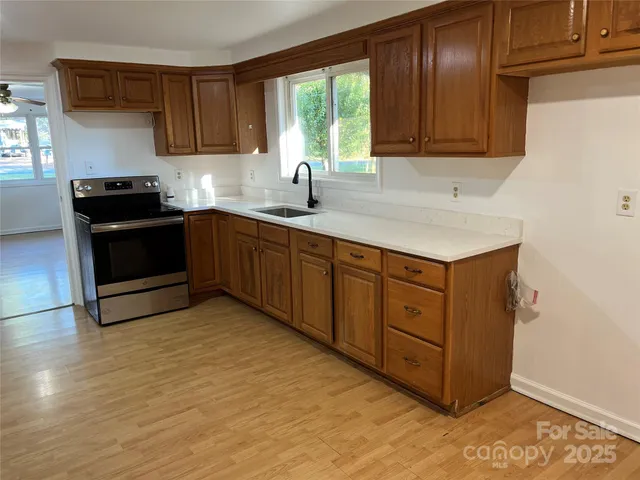 a kitchen with stainless steel appliances granite countertop a stove a sink and a microwave