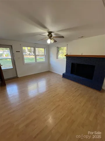 an empty room with windows and fireplace