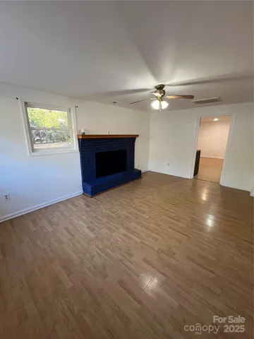 an empty room with windows and ceiling fan