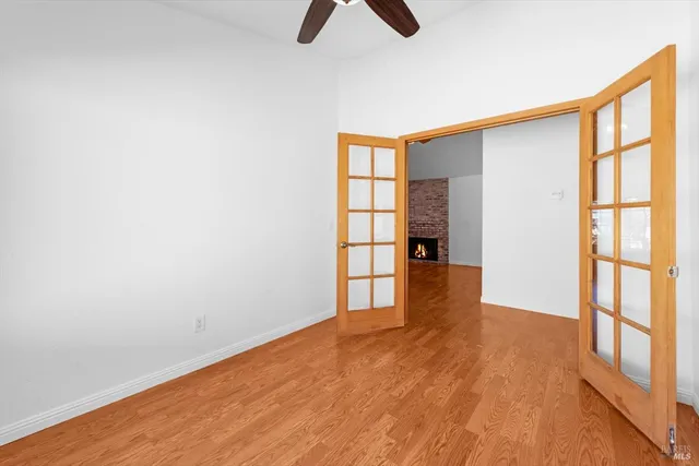 a view of an empty room with window and wooden floor