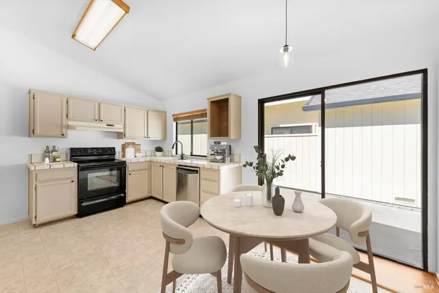 a kitchen with granite countertop white cabinets and stainless steel appliances