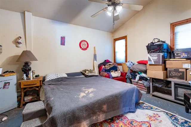 a bed room with a bed table and a chair