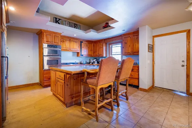 a dining hall with stainless steel appliances granite countertop a stove and a refrigerator