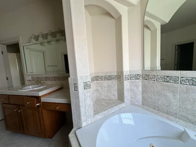 an empty room with windows and chandelier fan