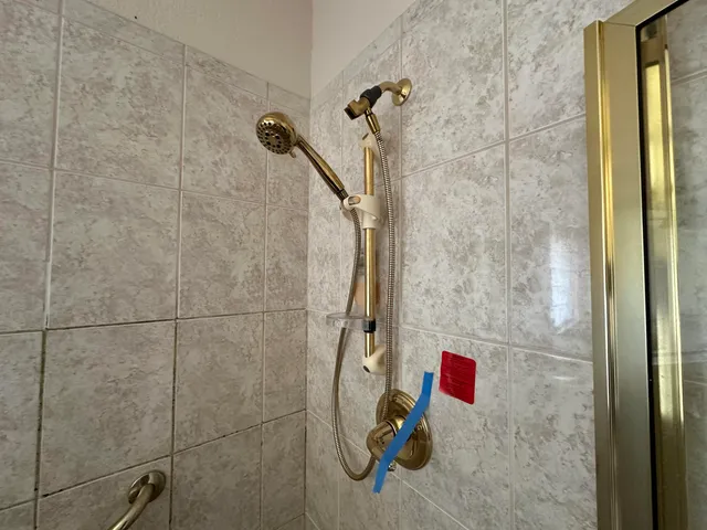 a kitchen with stainless steel appliances kitchen island granite countertop a refrigerator a stove and a sink with wooden cabinets