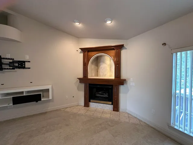 an empty room with a ceiling fan and window