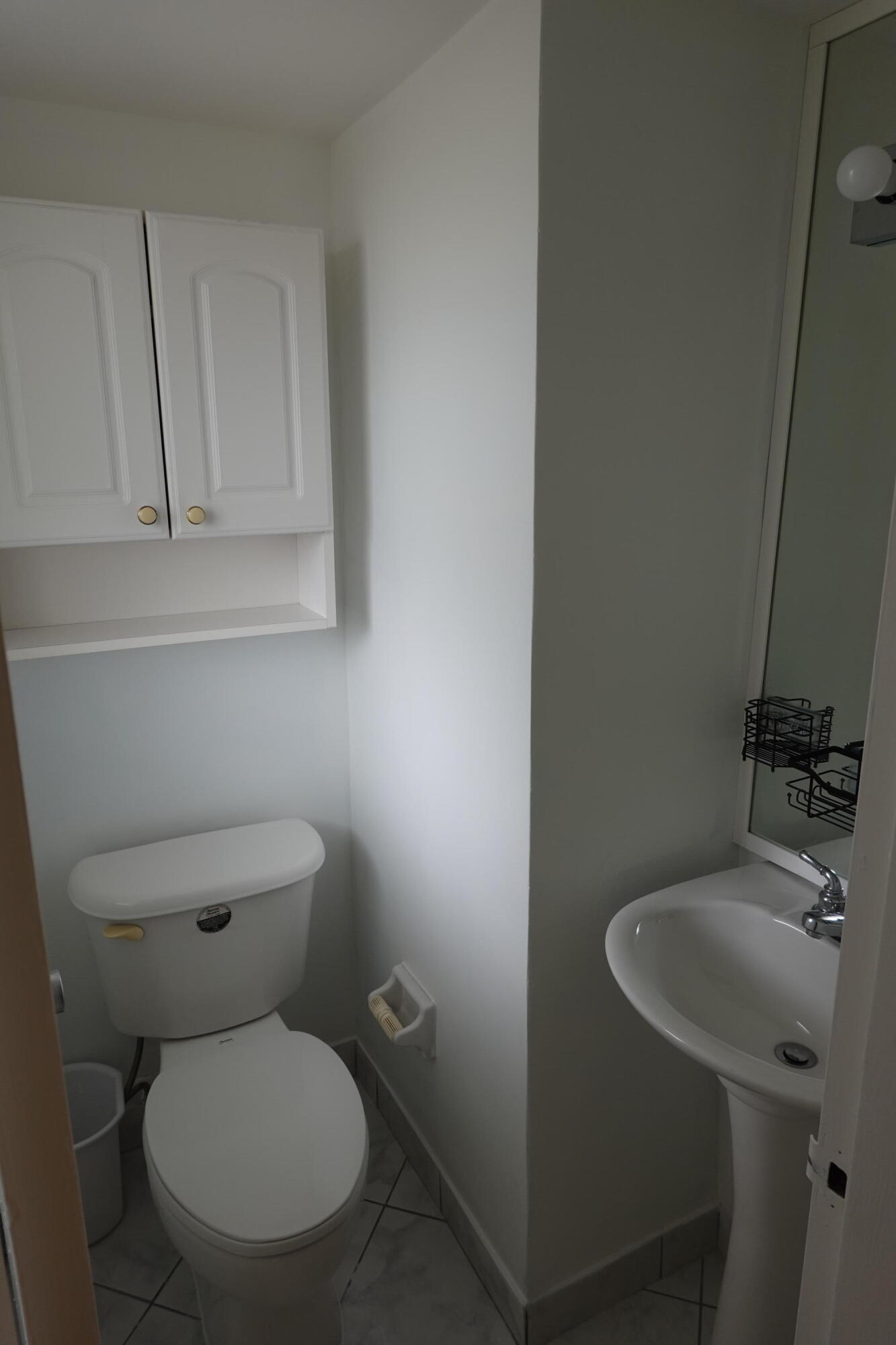 5321 Northeast 24th Terrace, Unit 112A Fort Lauderdale, FL 33308 - Photo 9 of 21 a white toilet sitting next to a bathroom sink