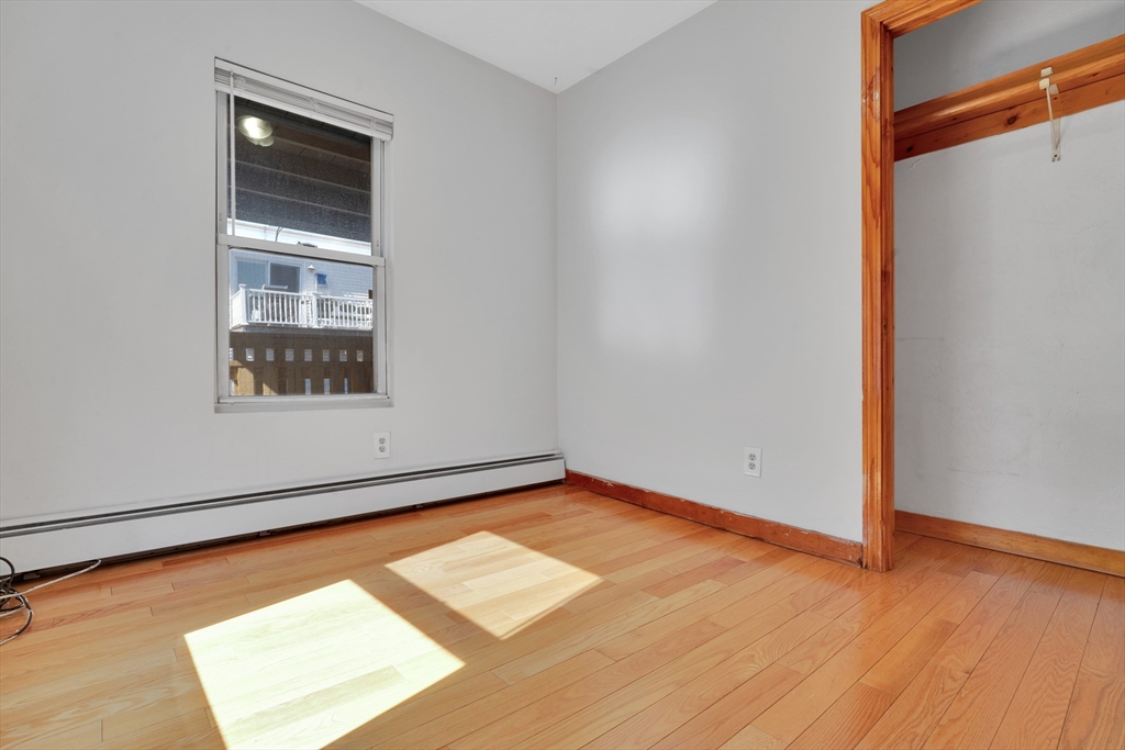 11 Carpenter Street, Unit 3 Boston, MA 02127 - Photo 15 of 22 a view of an empty room with wooden floor and a window
