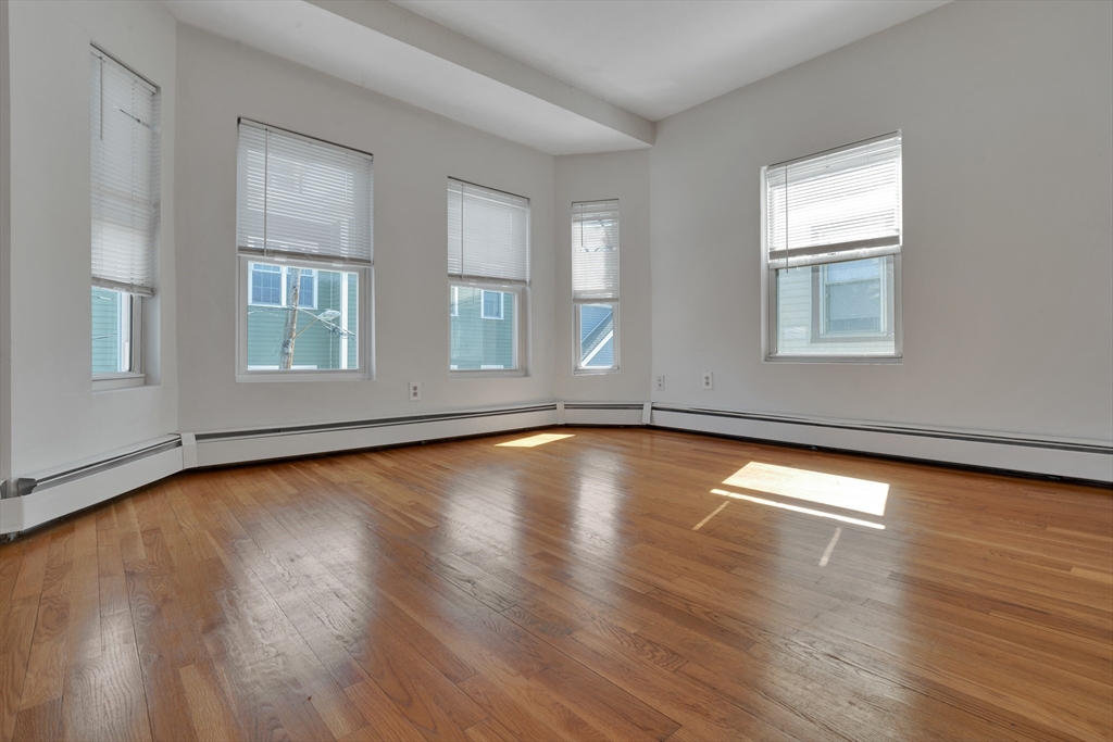 11 Carpenter Street, Unit 3 Boston, MA 02127 - Photo 19 of 22 an empty room with wooden floor and windows