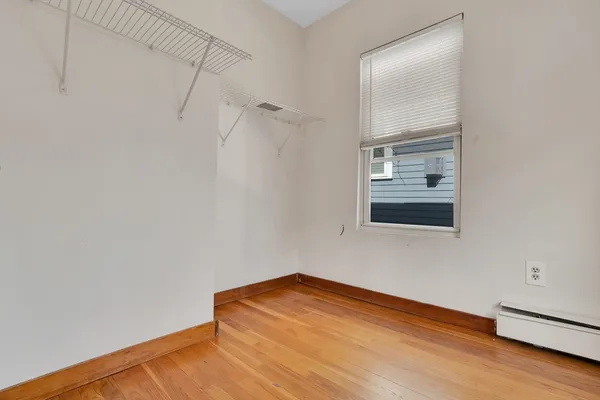 a view of a room with wooden floor and mirror