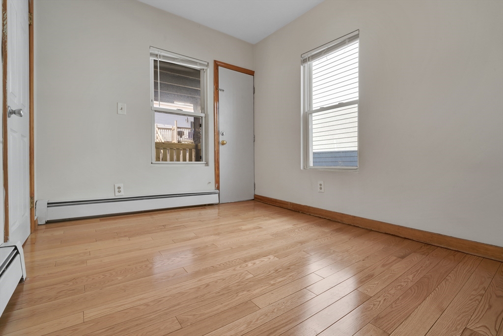 11 Carpenter Street, Unit 3 Boston, MA 02127 - Photo 10 of 22 an empty room with wooden floor and windows