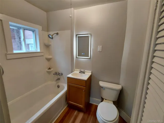 a white toilet sitting next to a bath tub