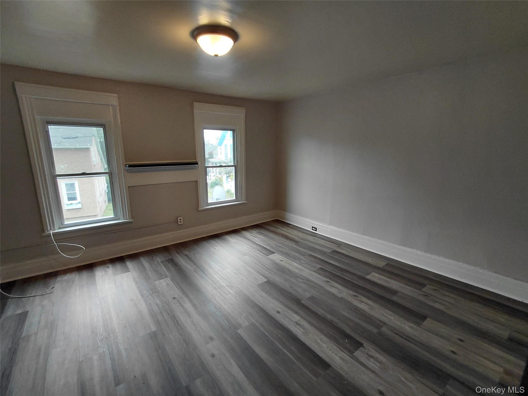 87 West Pierpont Street, Unit 4 Kingston, NY 12401 - Photo 8 of 13 an empty room with wooden floor and windows