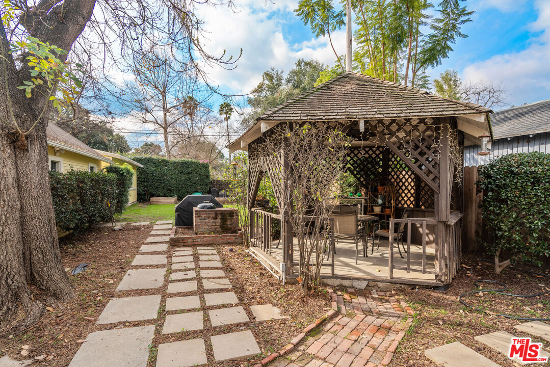 765 Mar Vista Avenue Pasadena, CA 91104 - Photo 30 of 42 a view of a patio with table and chairs under an umbrella with a small yard