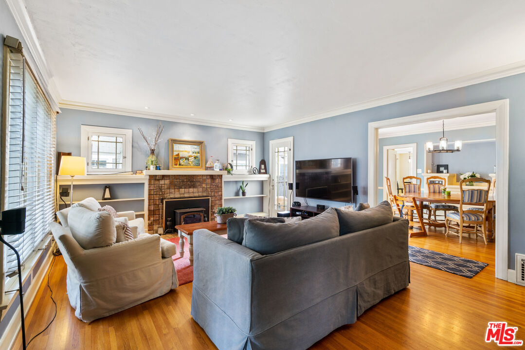 765 Mar Vista Avenue Pasadena, CA 91104 - Photo 6 of 42 a living room with furniture a flat screen tv and a fireplace