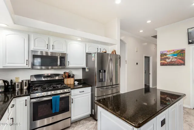 a kitchen with stainless steel appliances granite countertop a sink a stove and a refrigerator