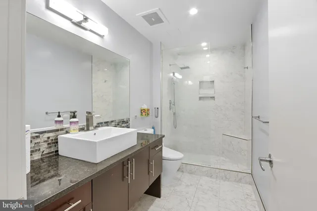 a bathroom with a sink a toilet and shower