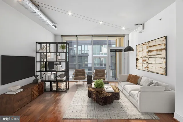 a living room with furniture a rug and a flat screen tv
