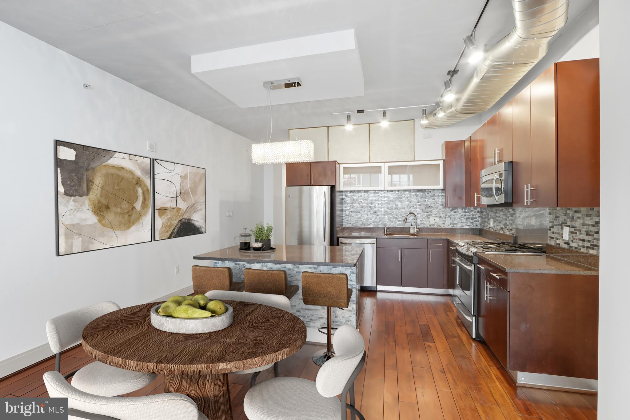 929 Florida Avenue Northwest, Unit 8001 Washington, DC 20001 - Photo 4 of 15 a kitchen with stainless steel appliances kitchen island granite countertop a table and chairs