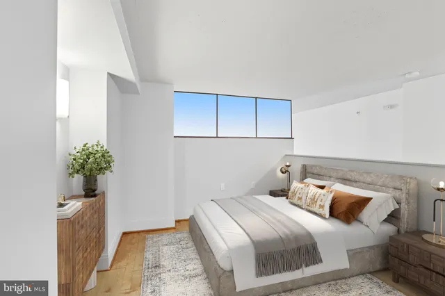 a bedroom with a bed and a potted plant