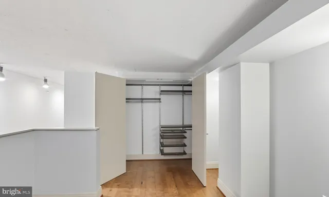 a view of walk in closet with wooden floor