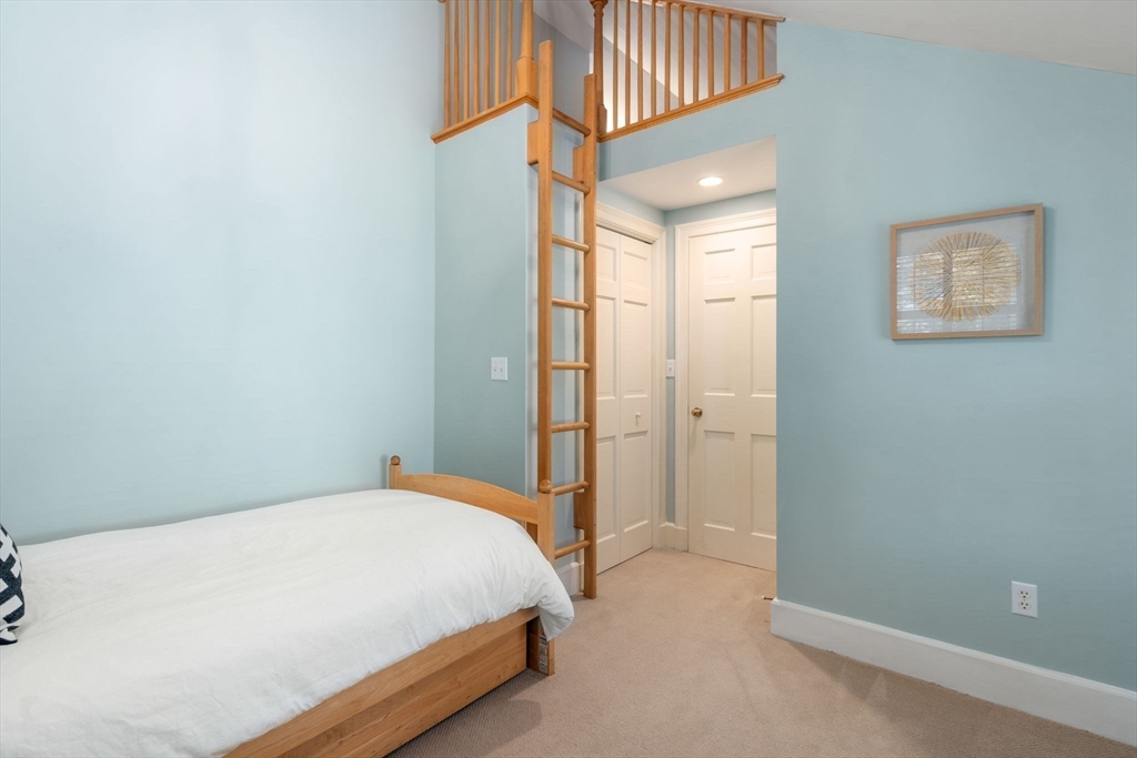 30 Park Avenue Wellesley, MA 02481 - Photo 24 of 36 a bedroom with a bed and a chandelier