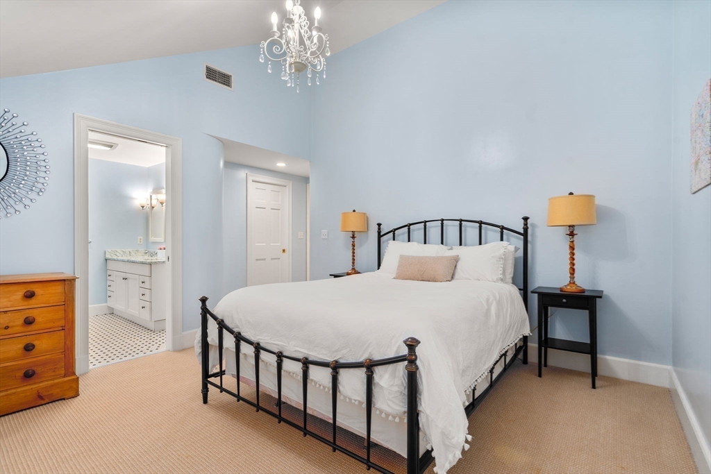 30 Park Avenue Wellesley, MA 02481 - Photo 25 of 36 a bedroom with a bed and a chandelier
