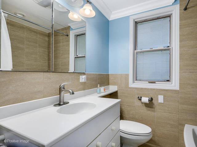 2510 North Burling Street, Unit 1 Chicago, IL 60614 - Photo 8 of 9 a bathroom with a sink toilet a mirror and shower