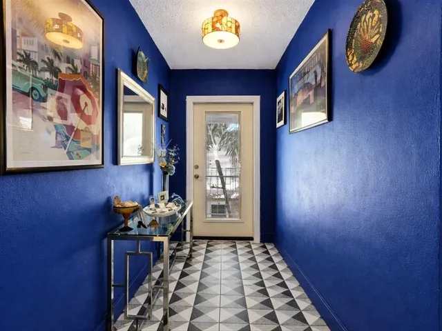 a hallway with painting on the wall and a window