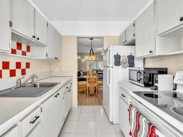 a kitchen with stainless steel appliances granite countertop a sink and a refrigerator