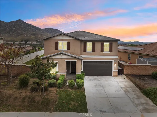 a front view of a house with yard and parking