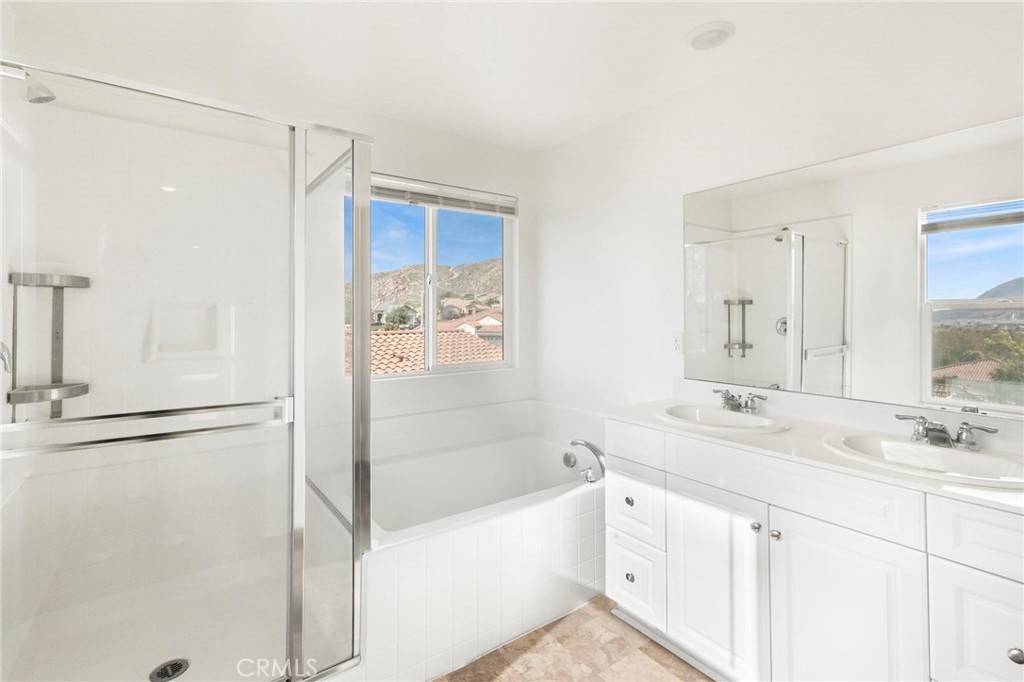 20765 Barn Road Riverside, CA 92507 - Photo 32 of 56 a bathroom with a bathtub sink vanity and mirror
