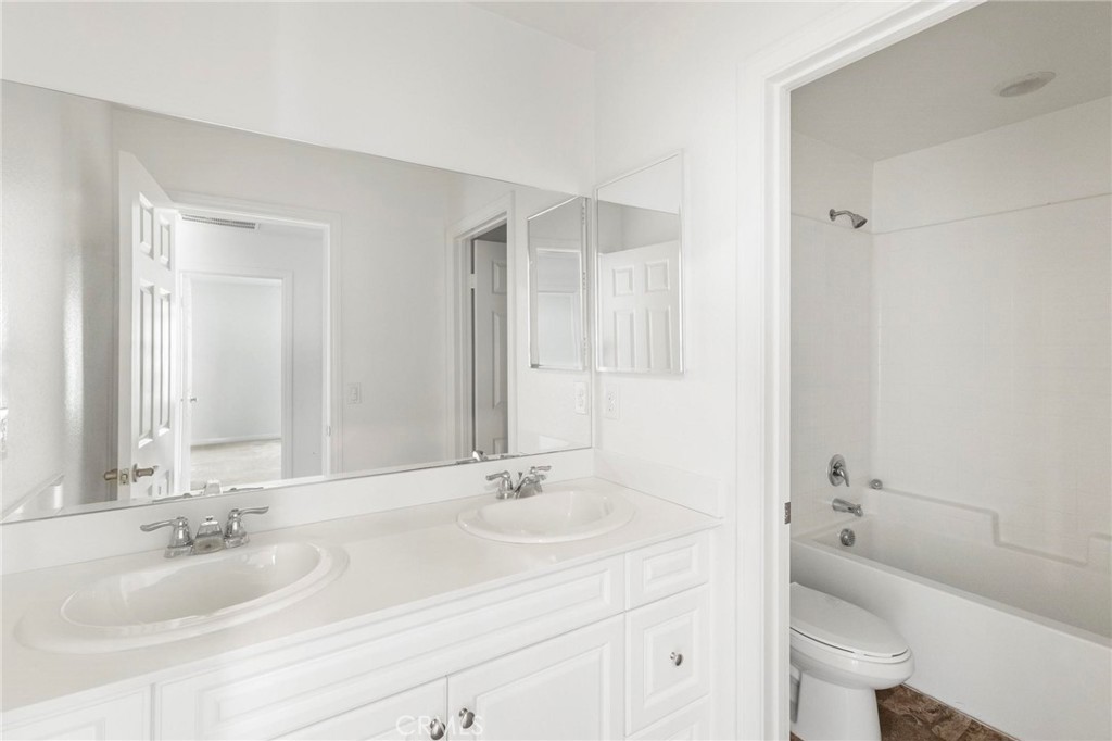 20765 Barn Road Riverside, CA 92507 - Photo 42 of 56 a bathroom with a granite countertop sink a toilet and a large mirror