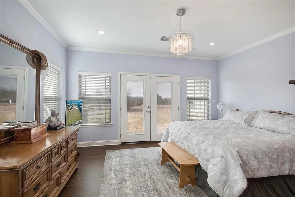 125 Heritage Road Gordonville, TX 76245 - Photo 28 of 40 a spacious bedroom with a bed a dresser and large windows